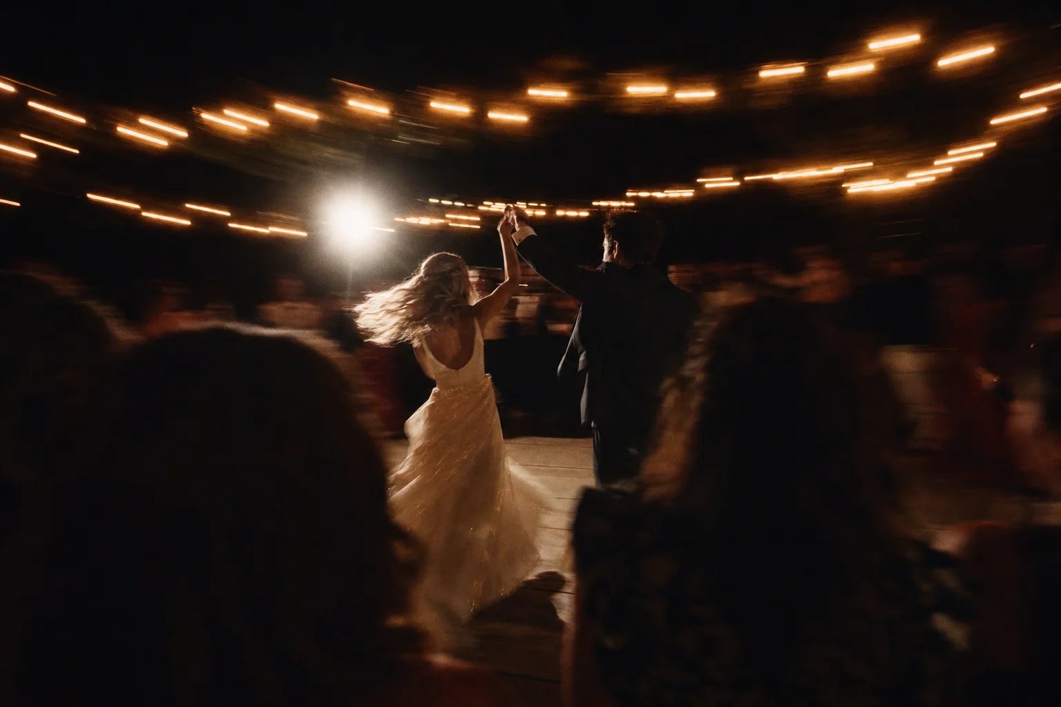 Newlyweds turning on a warmly lit dance floor
